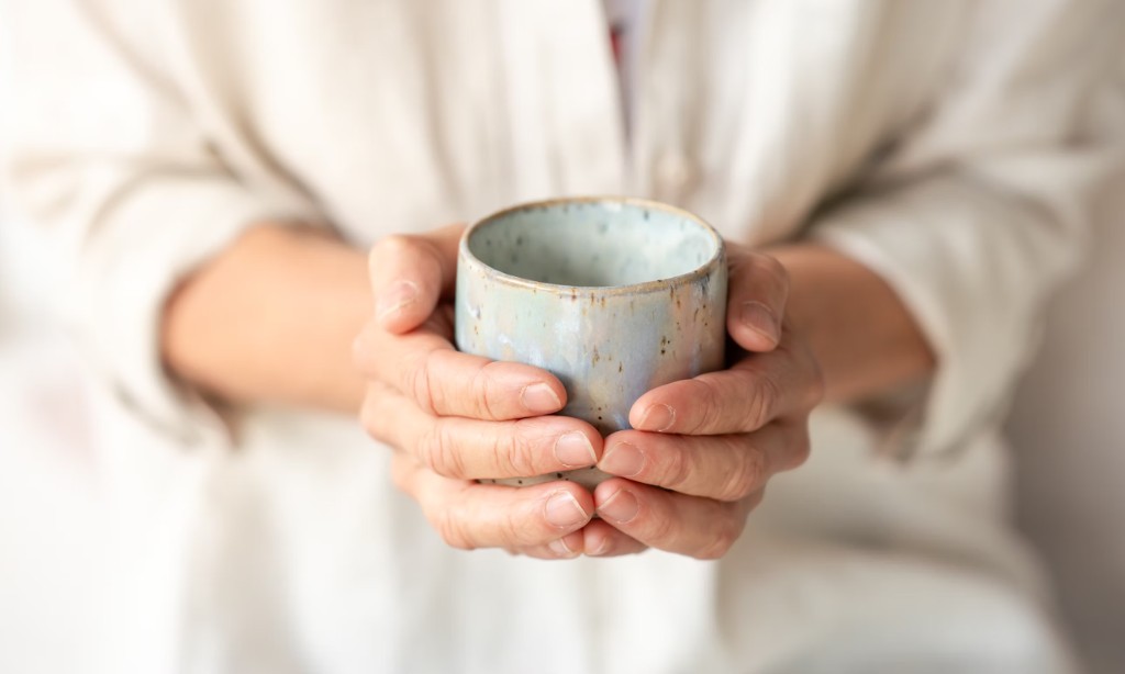 Hände halten behutsam eine Tasse – ein Moment von Geborgenheit