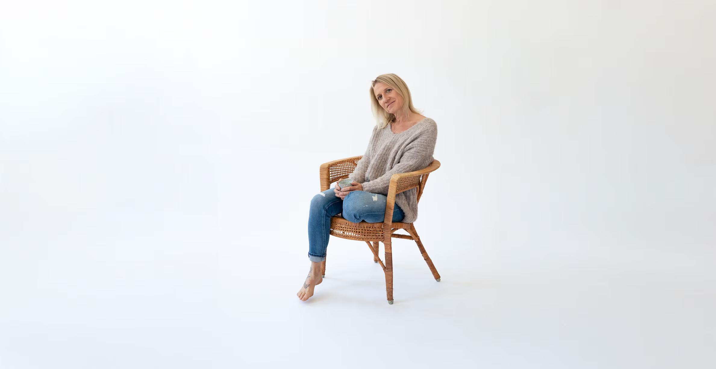 Stefanie Kneidinger sitzt entspannt in einem Korbstuhl