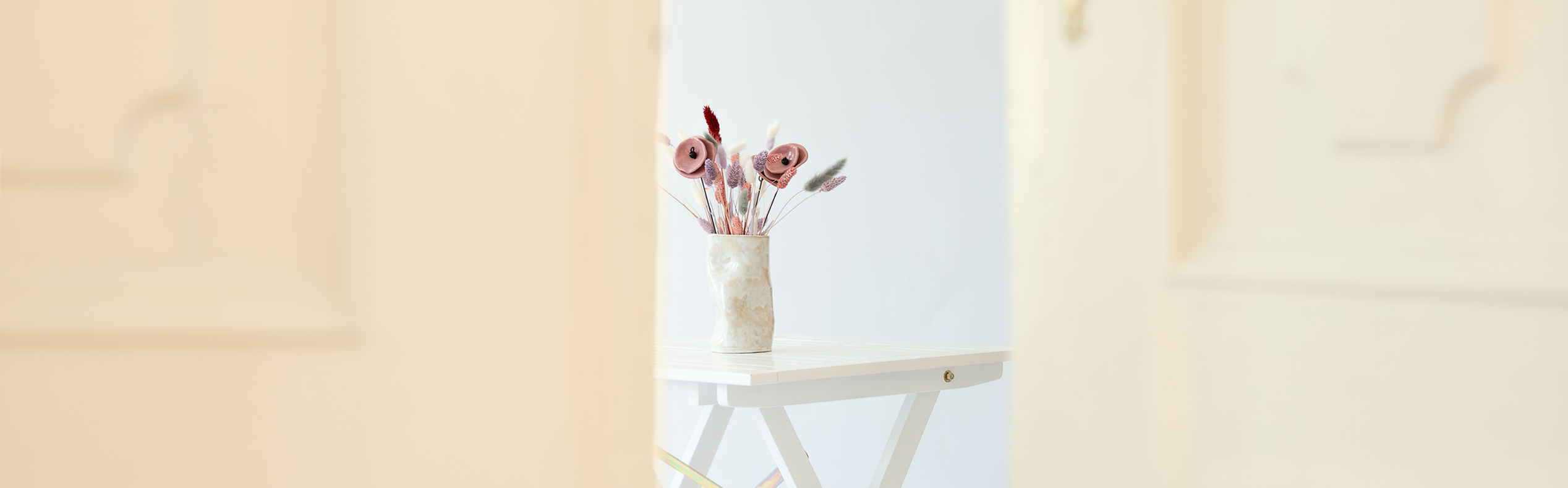 Ein ruhiger Raum mit einem kleinen Tisch und getrockneten Blumen – ein Moment der Stille
